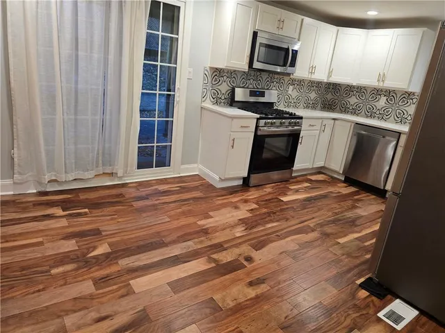 a kitchen with granite countertop a stove and a microwave