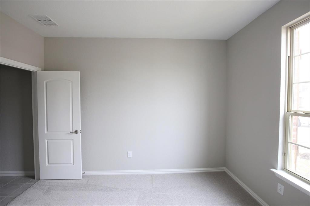 15142 Rosario Road Frisco, TX 75035 - Photo 18 of 21 Carpeted room with light neutral wall paint, white trim, a single window with grids, and a white panel door