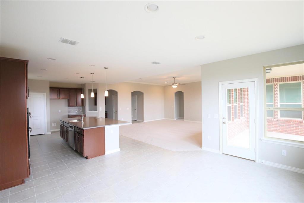 15142 Rosario Road Frisco, TX 75035 - Photo 7 of 21 Open-concept living space featuring a kitchen island with pendant lighting, integrated appliances, recessed lighting, tile flooring, and arched doorways