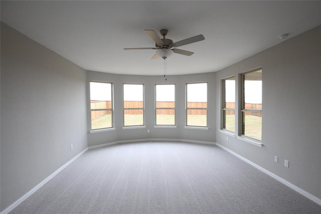 15142 Rosario Road Frisco, TX 75035 - Photo 10 of 21 Spacious room featuring a bay of five windows, neutral wall tones, light gray carpeting, and a ceiling fan