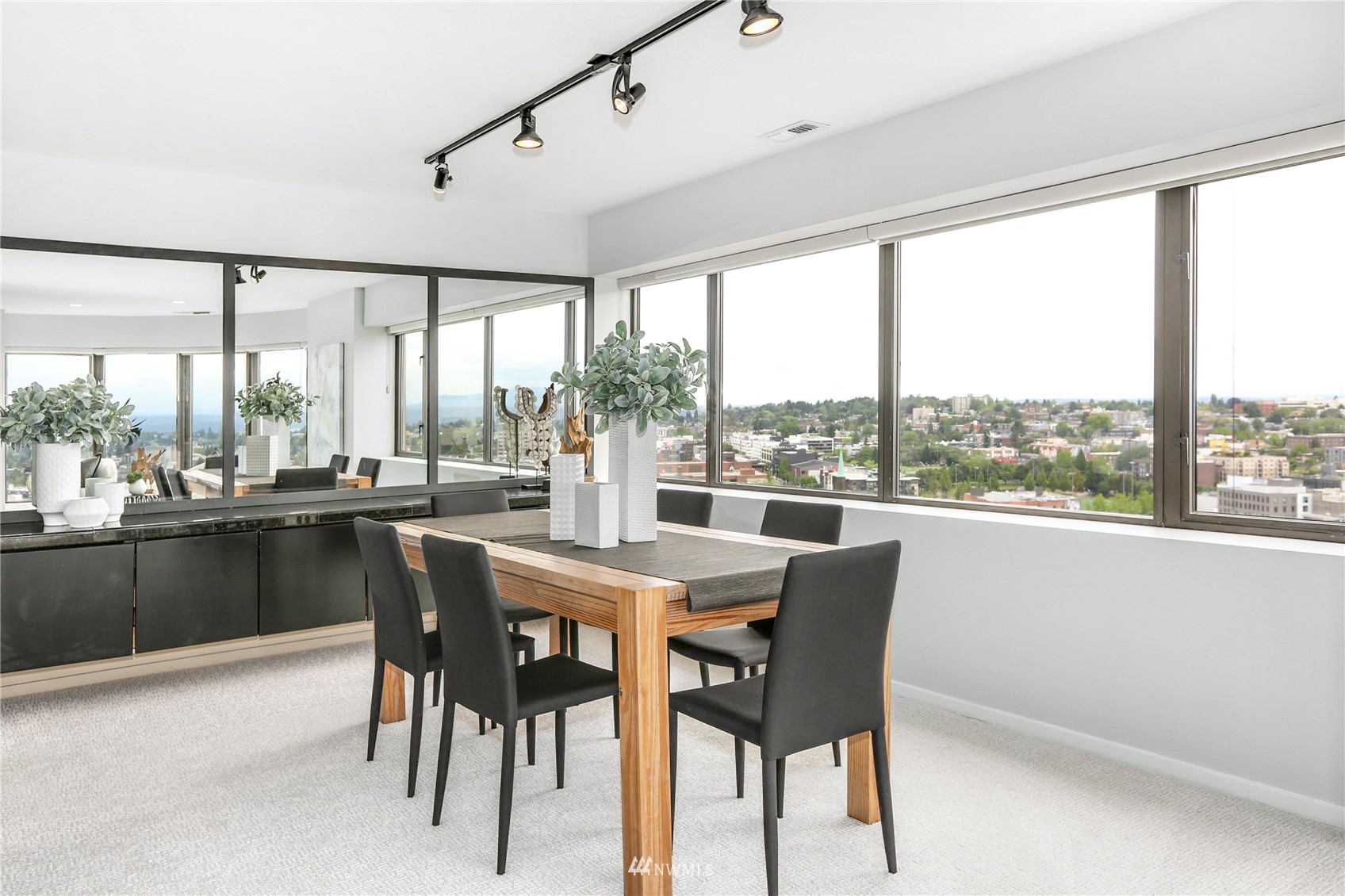1301 Spring Street, Unit 18H Seattle, WA 98104 - Photo 8 of 38 a dining room with furniture large windows and a chandelier