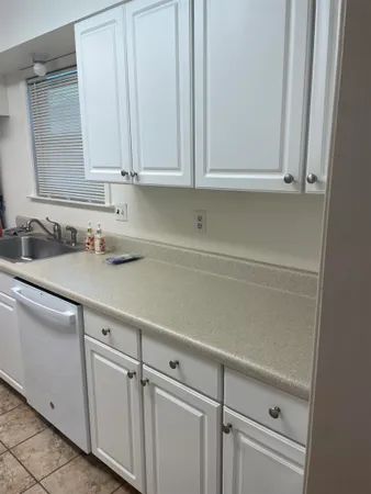 a kitchen with white cabinets and a sink