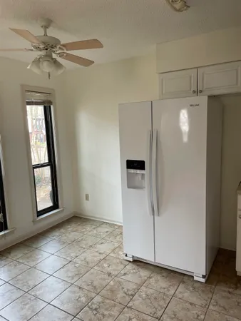 an empty room with windows and fan