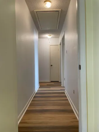 a view of a hallway with wooden floor