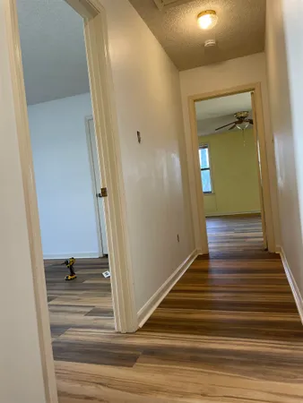 a view of a hallway with wooden floor and staircase