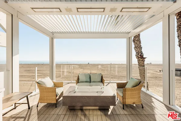 a living room with furniture and floor to ceiling windows