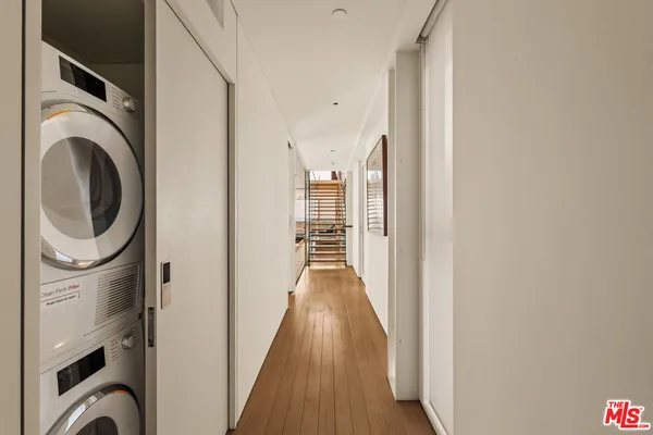 a view of a hallway with wooden floor and closet