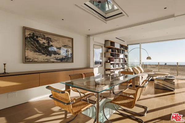 a view of a dining room with furniture a rug and wooden floor