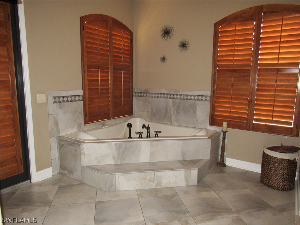 31031 Oil Well Road Punta Gorda, FL 33955 - Photo 12 of 22 a bath tub sitting in a bathroom next to a sink