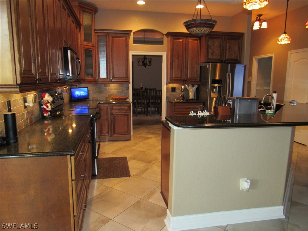 31031 Oil Well Road Punta Gorda, FL 33955 - Photo 6 of 22 a kitchen with stainless steel appliances granite countertop a refrigerator and a sink