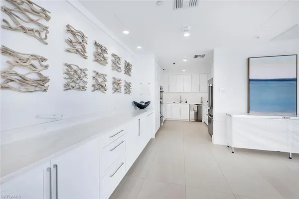 a kitchen with white cabinets and white appliances