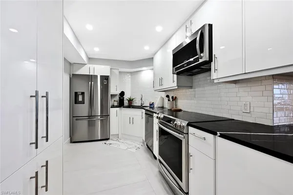 a kitchen with stainless steel appliances a stove microwave and refrigerator