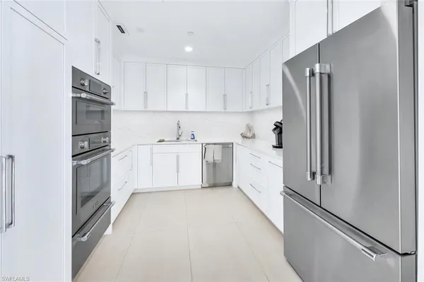 a kitchen with white cabinets and white stainless steel appliances