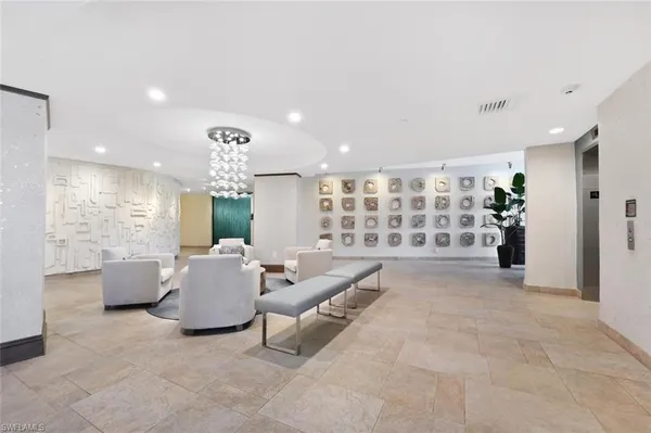 a living room with furniture a chandelier and pool table