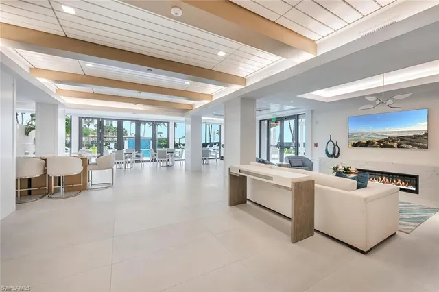 a living room with furniture a large window and a chandelier