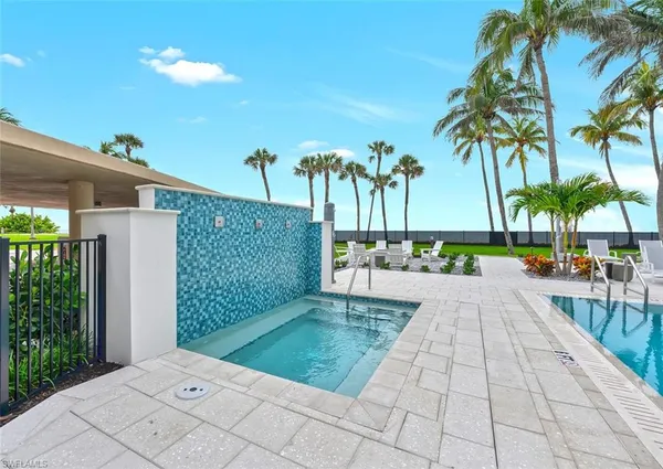 a view of a swimming pool with chairs and plants