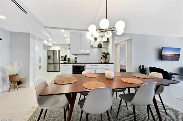 a dining room filled chandelier and wooden floor
