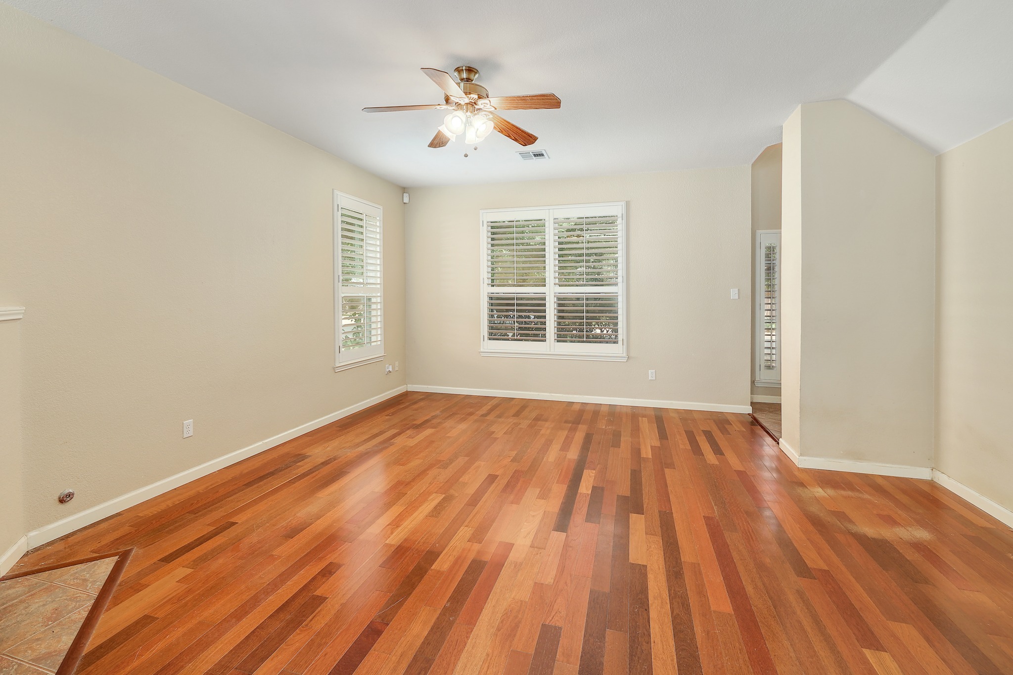 4615 Tello Path Austin, TX 78749 - Photo 4 of 31 Rich hardwood flooring anchors this versatile living space highlighted by classic plantation shutters.