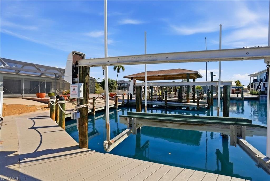 1 Fairview Boulevard Fort Myers Beach, FL 33931 - Photo 26 of 48 Private dock with boat lift, composite decking, and direct water access - Virtually Edited Image