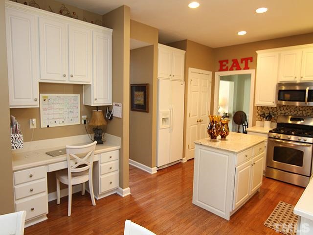 1508 Wood Spring Court Raleigh, NC 27614 - Photo 7 of 25 a kitchen with a refrigerator a stove top oven a sink dishwasher and white cabinets with wooden floor