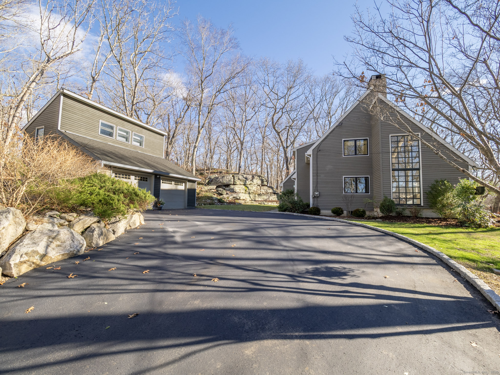 a front view of a house with a yard and large trees