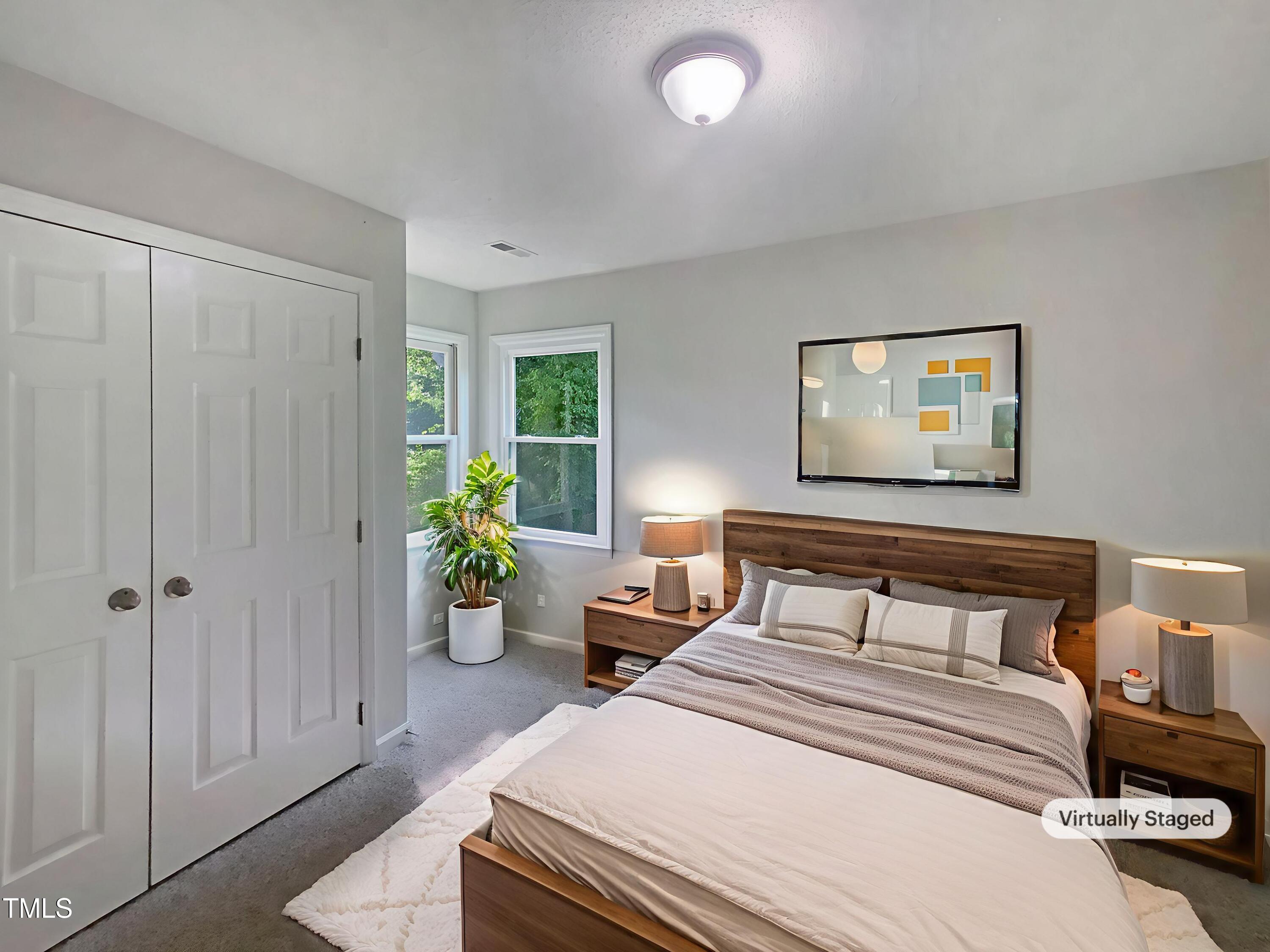 2301 Declaration Drive Raleigh, NC 27615 - Photo 4 of 19 a bedroom with a bed and potted plant