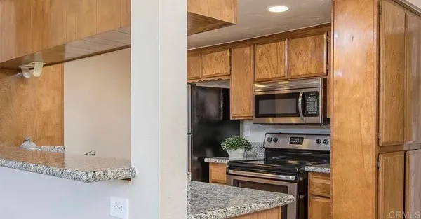 a kitchen with stainless steel appliances granite countertop a stove and a microwave