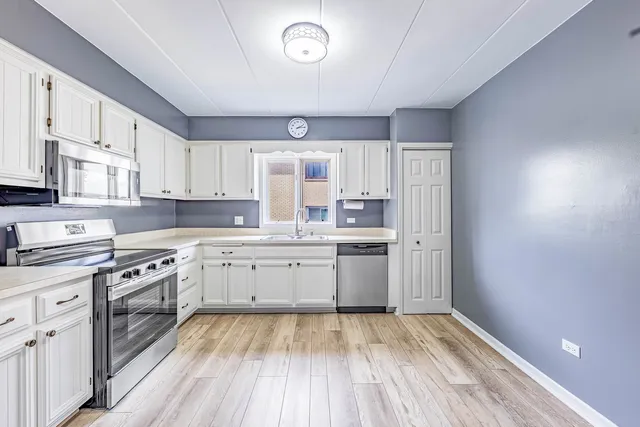 a kitchen with granite countertop white cabinets and white appliances