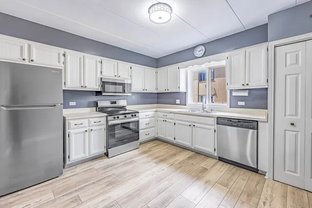 a kitchen with granite countertop white cabinets and white appliances