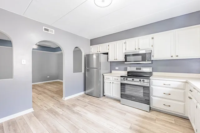 a kitchen with stainless steel appliances a stove a refrigerator and cabinets