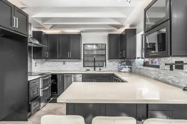 a kitchen with a stove a sink a table and chairs