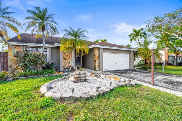a view of a house with backyard and a tree