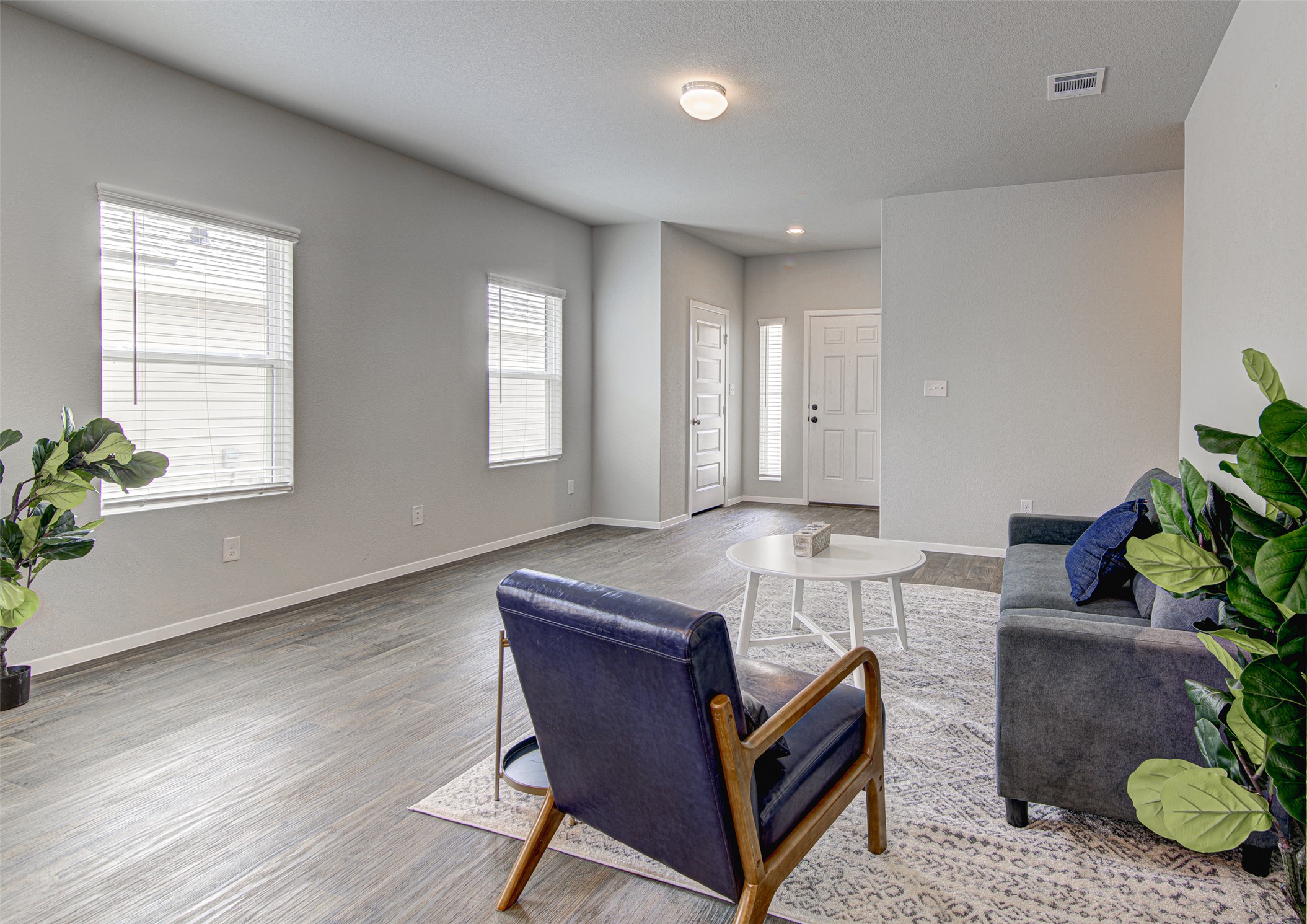 156 Tillage Road Elgin, TX 78621 - Photo 7 of 25 An inviting open-concept living area with abundant natural illumination and durable hardwood flooring.