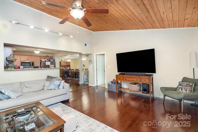 a kitchen with granite countertop wooden floors stainless steel appliances and a counter space