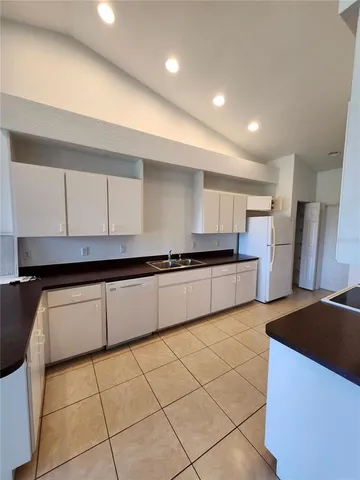 a kitchen with stainless steel appliances granite countertop a sink and white cabinets
