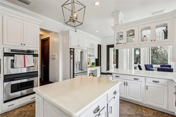a open kitchen with white cabinets and stainless steel appliances