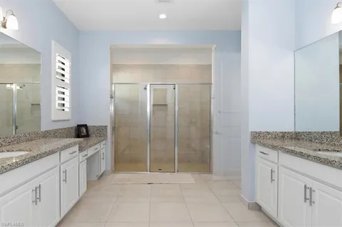 a spacious bathroom with a granite countertop sink a mirror and a vanity