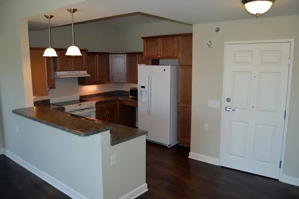 a kitchen with stainless steel appliances granite countertop a refrigerator a sink and a stove