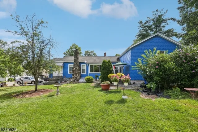 a front view of a house with garden and sitting area