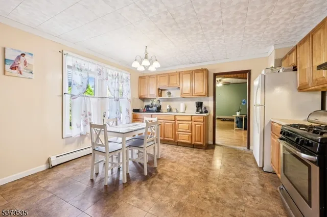 a kitchen with granite countertop stainless steel appliances a table and chairs in it