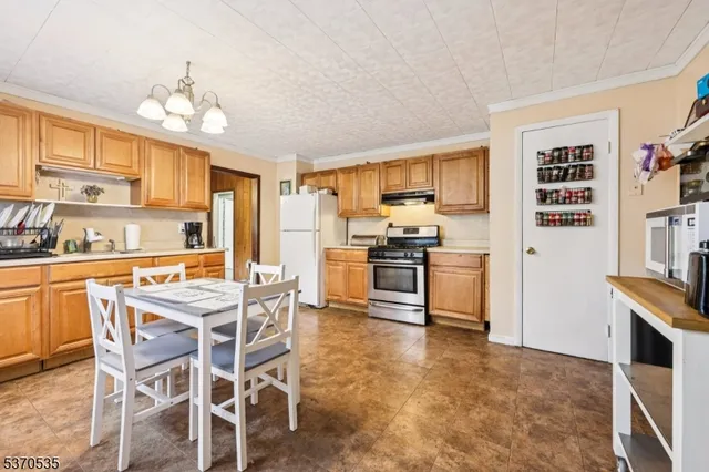 a kitchen with stainless steel appliances kitchen island granite countertop a stove top oven a sink dishwasher and a refrigerator