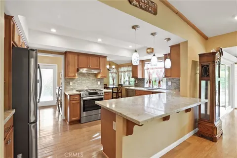 a large kitchen with stainless steel appliances granite countertop a large counter top and a refrigerator