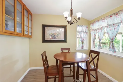 a dining room with wooden floor and chandelier