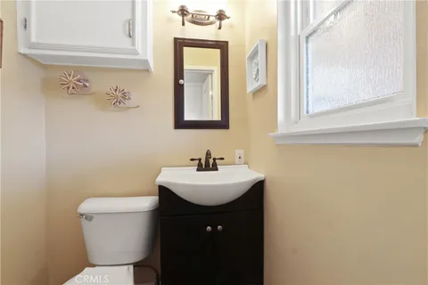 a bathroom with a sink a toilet and mirror