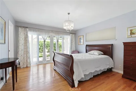 a bedroom with a large bed and a chandelier