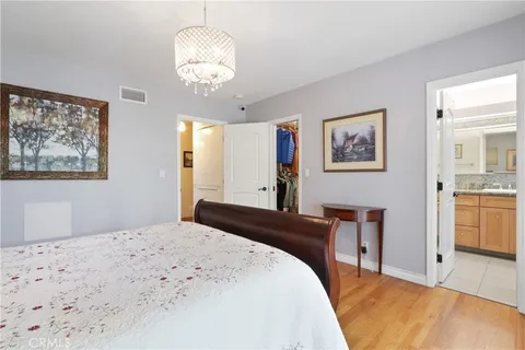 a bedroom with a large bed and a chandelier