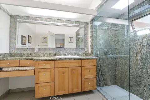 a bathroom with a granite countertop sink mirror vanity and toilet