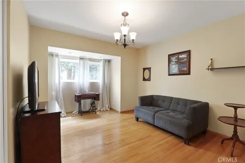 a living room with furniture two window and a chandelier