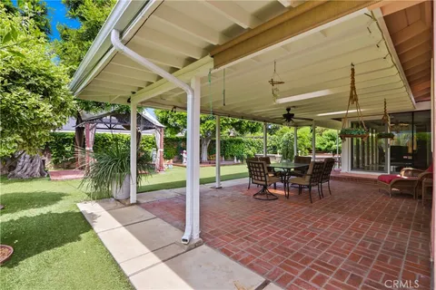 a view of a patio with table and chairs under an umbrella
