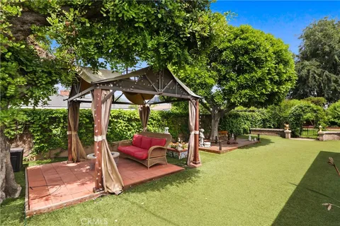 a view of a patio with table and chairs under an umbrella
